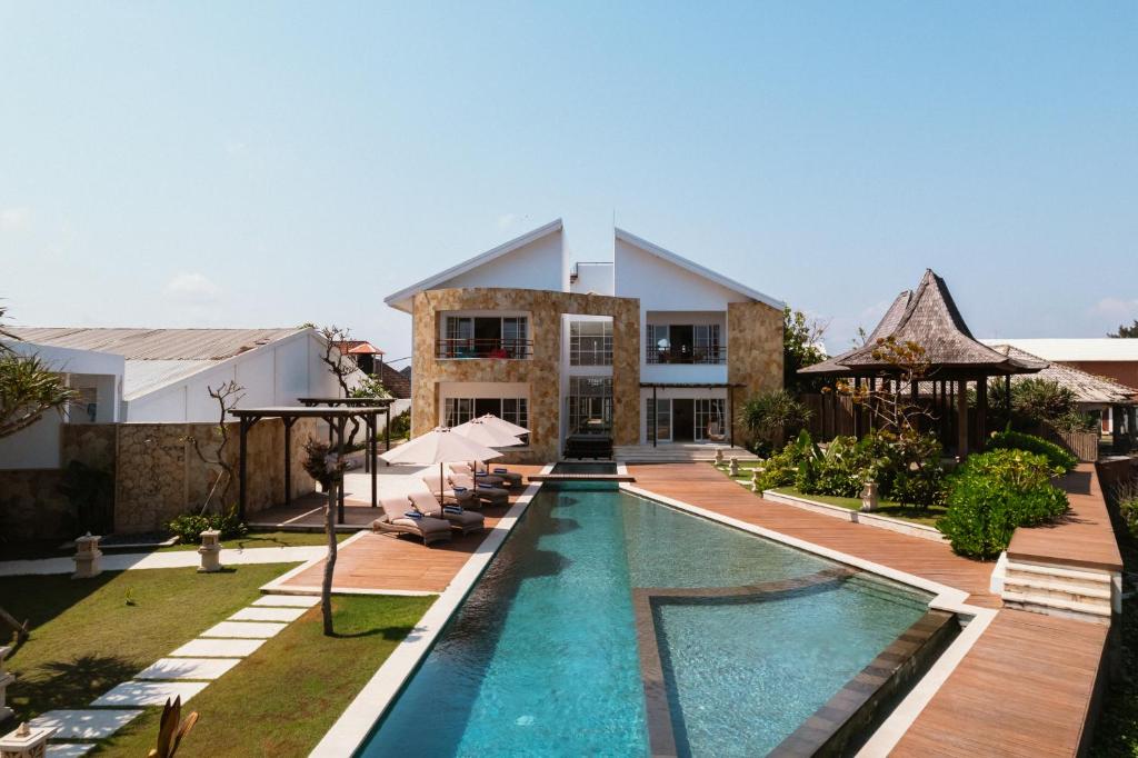 a swimming pool in front of a house at Nalas Villa in Ketewel