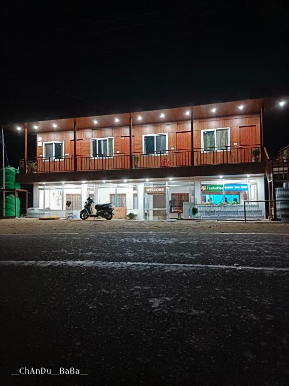 a motorcycle parked in front of a building at night at Hotel Amit Kedar Dham in Sirsi