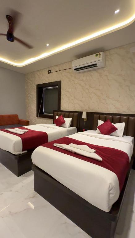 a hotel room with two beds and a television at Sova Premium in Jagatsinghapur