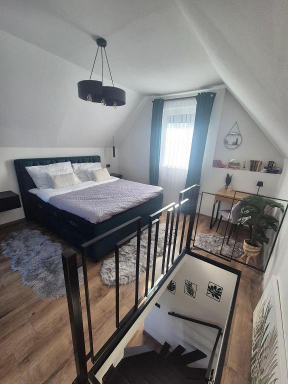 a small bedroom with a bed and a staircase at Holiday house Aria Vučedol in Vukovar
