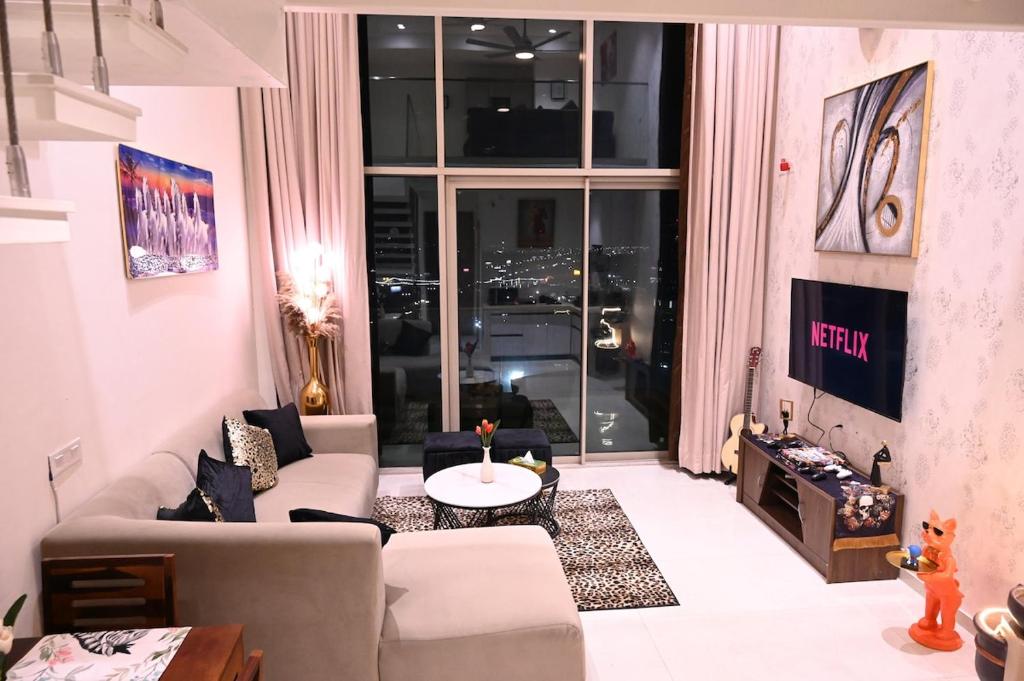 a living room with a couch and a large window at Let's Loft - A Premium Luxury Style Duplex Living in Gurgaon