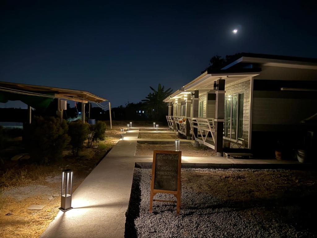 a sign in front of a trailer at night at บ้านสวนจุกทิพย์ โฮมสเตย์ in Ban Sam Kaeo