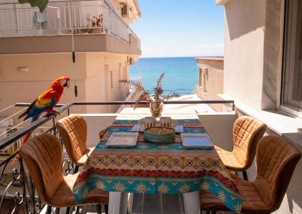 a parrot standing on a balcony with a table and chairs at Parrot Palazzo in Nea Kallikrateia