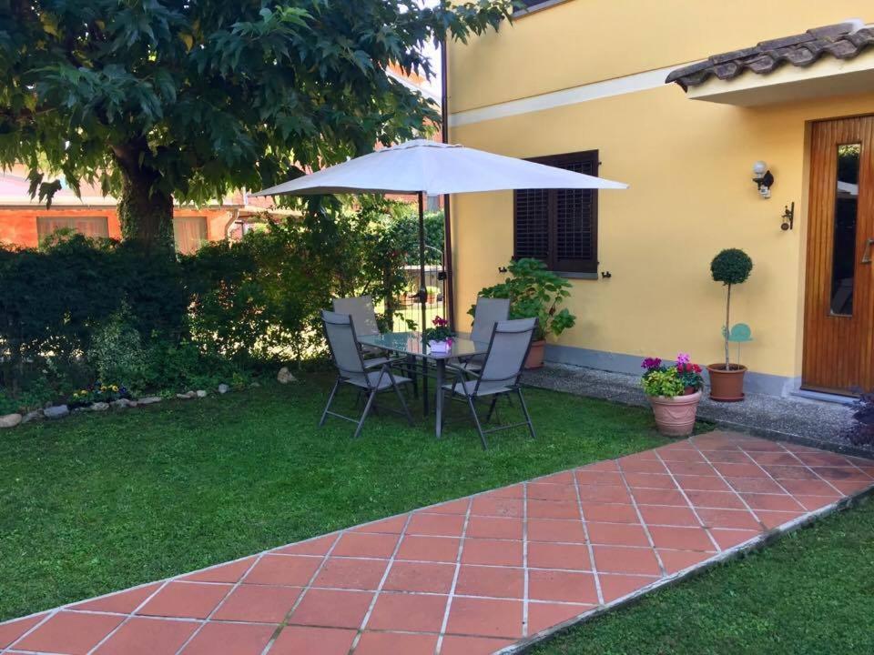 a patio with a table and an umbrella in a yard at "Lilla" in Calci