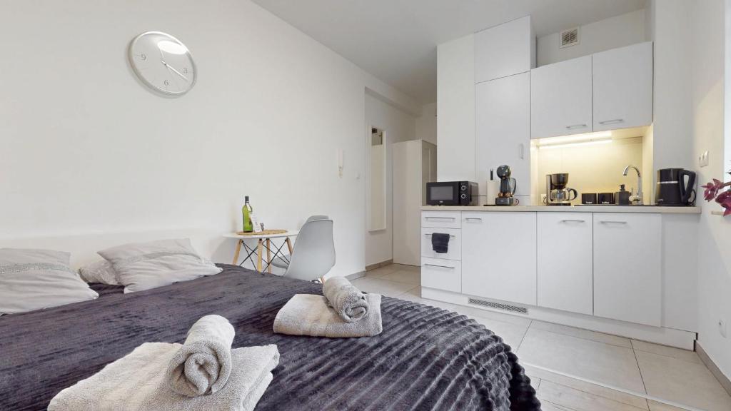 a white bedroom with a bed with towels on it at Studio Fibra Metrio in Rybnik