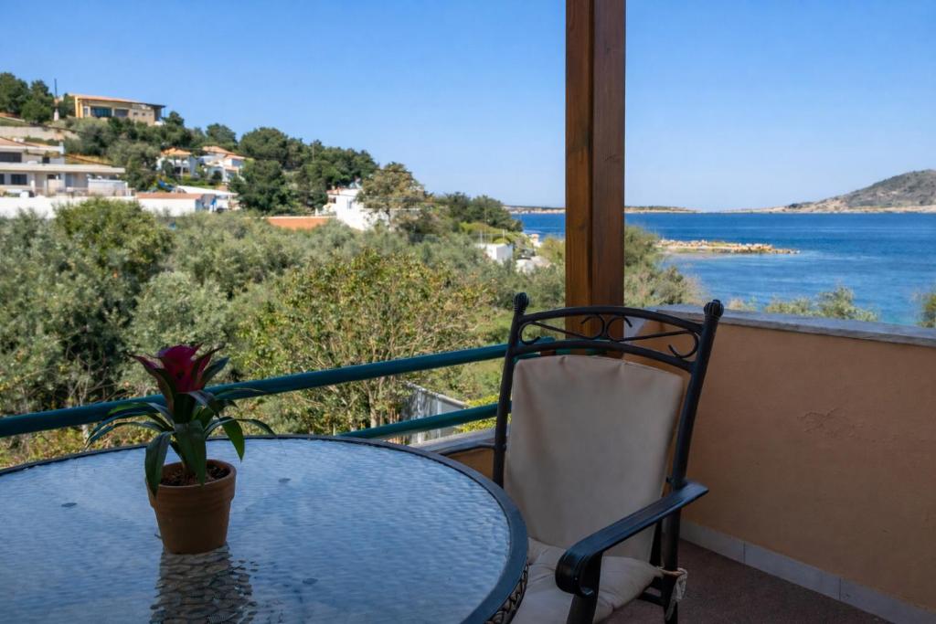 a table and chair on a balcony with a view of the ocean at Agali Beach Apartments Seaside Stay in Chios in Mármaron