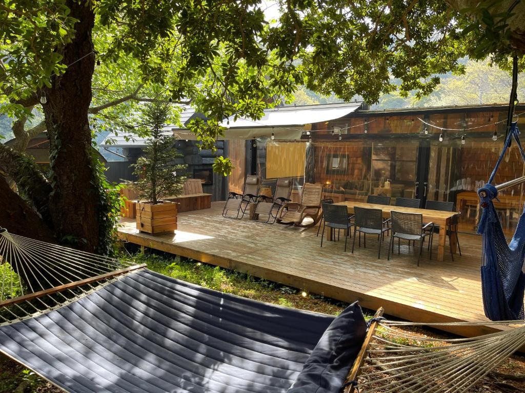 a hammock in a yard with a house at Tiny Base in Kawazu