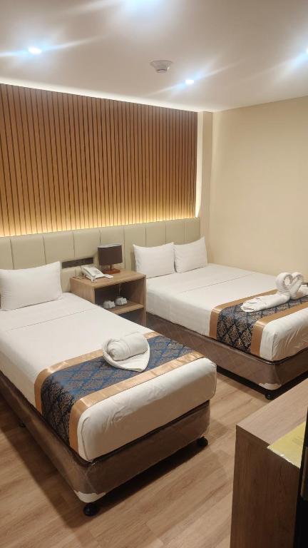 a hotel room with two beds and a desk at SVJ Hotel in Cebu City