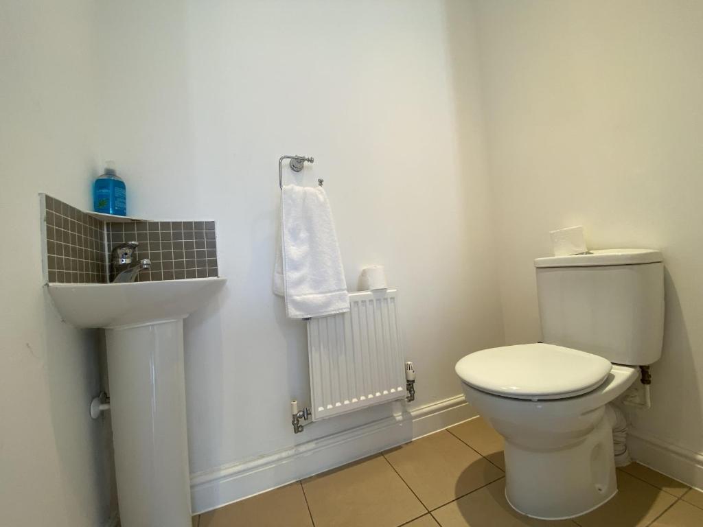 a bathroom with a white toilet and a sink at Spacious Bracknell Four Bedroom House in Bracknell