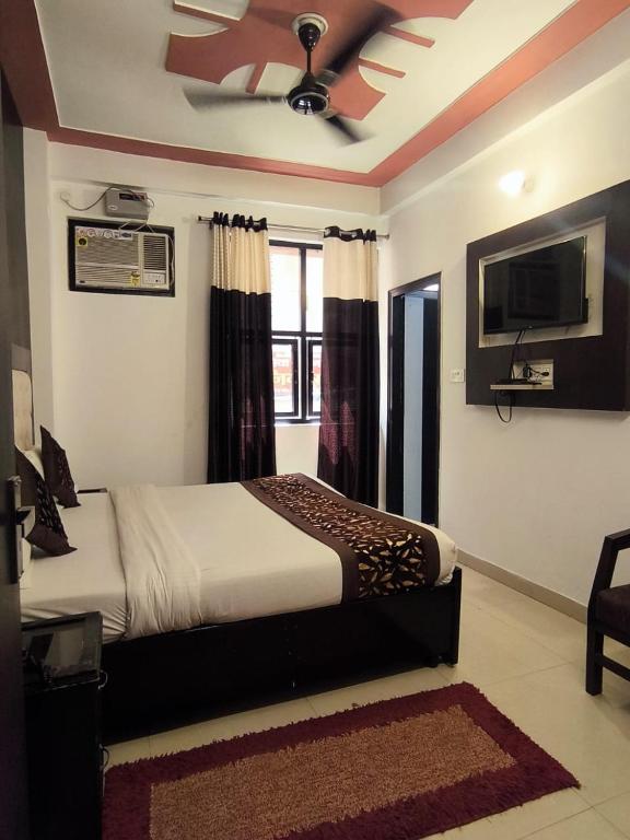 a bedroom with a bed and a ceiling fan at Hotel Jalsa in Haridwār