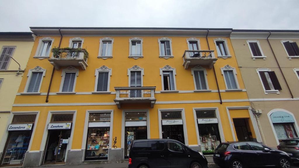 a yellow building with cars parked in front of it at Fp Monza Railways in Monza