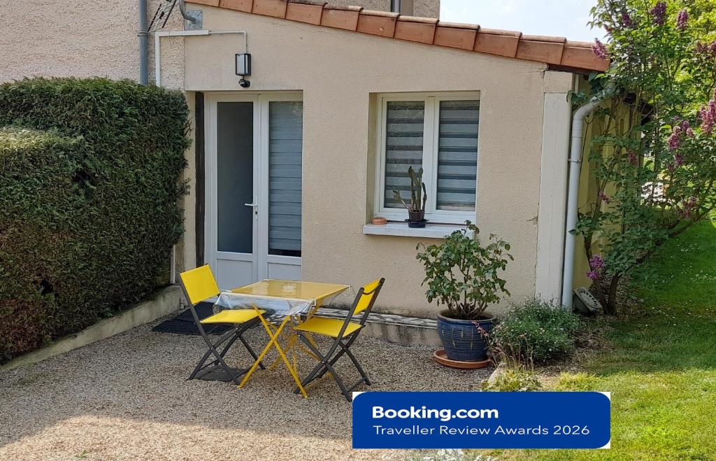 a table and chairs in front of a house at Le PATSA de Vouillé in Vouillé