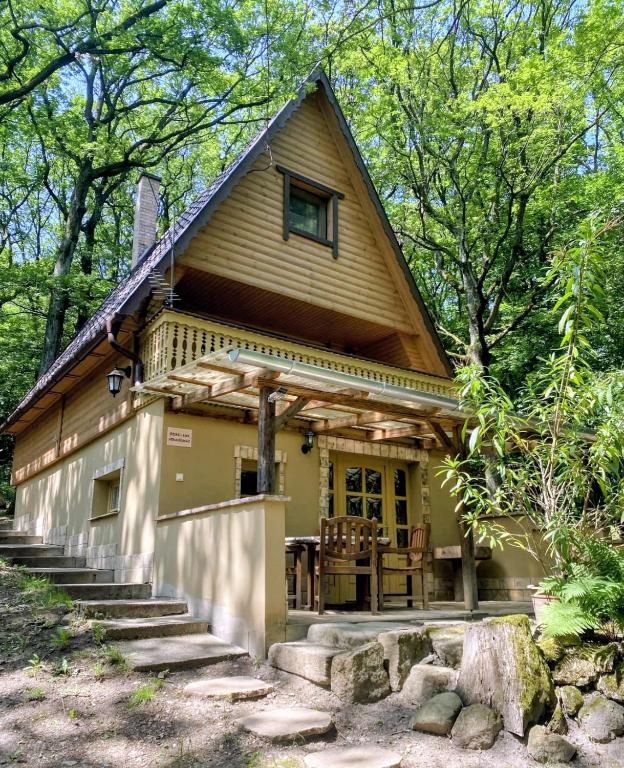 a house with a gambrel roof with stairs leading to it at Őzike-Lak a Börzsönyben in Kismaros