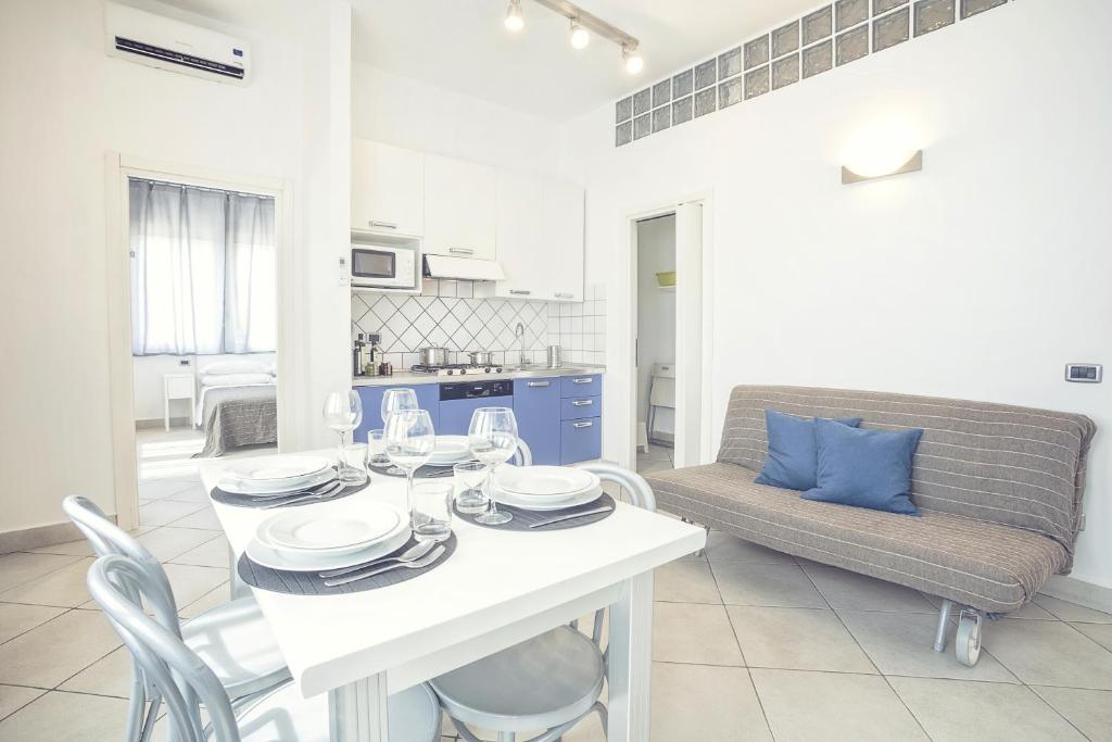 a dining room with a white table and a couch at Excelsior in Piombino