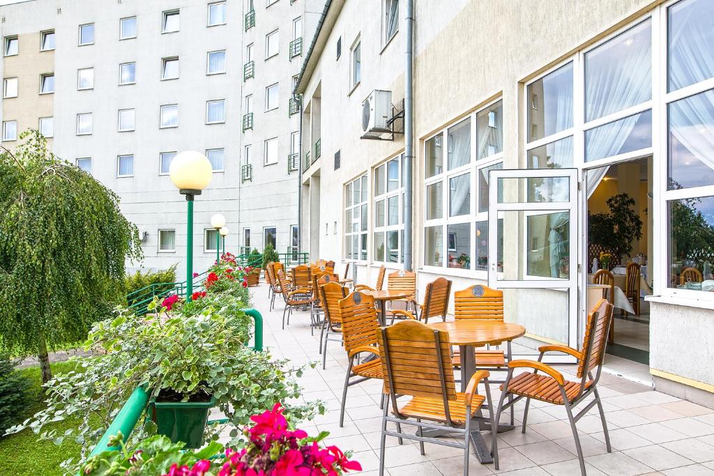 patio z krzesłami i stołami oraz budynek w obiekcie Hotel Accademia w mieście Przemyśl