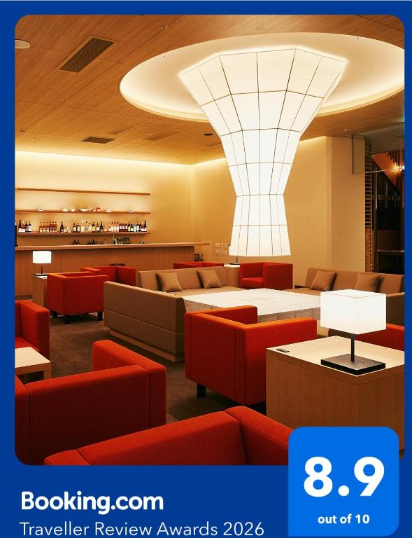 a restaurant with red chairs and tables and a ceiling at Kaisenkaku in Aomori
