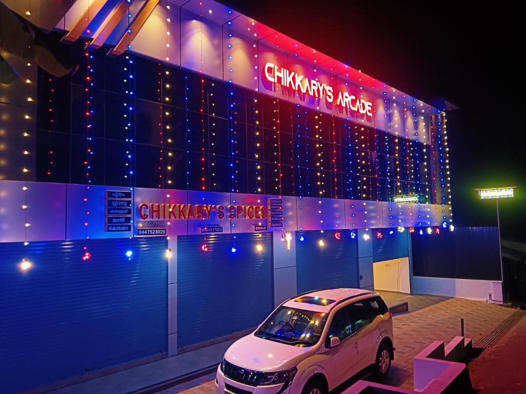 a car parked in front of a building with christmas lights at Chikkary's Inn in Munnar