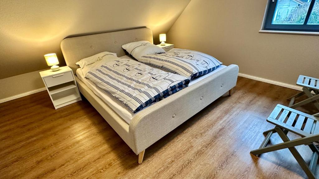 a bed in a bedroom with two lights on two tables at Fewo Ostseetraum Laboe in Laboe