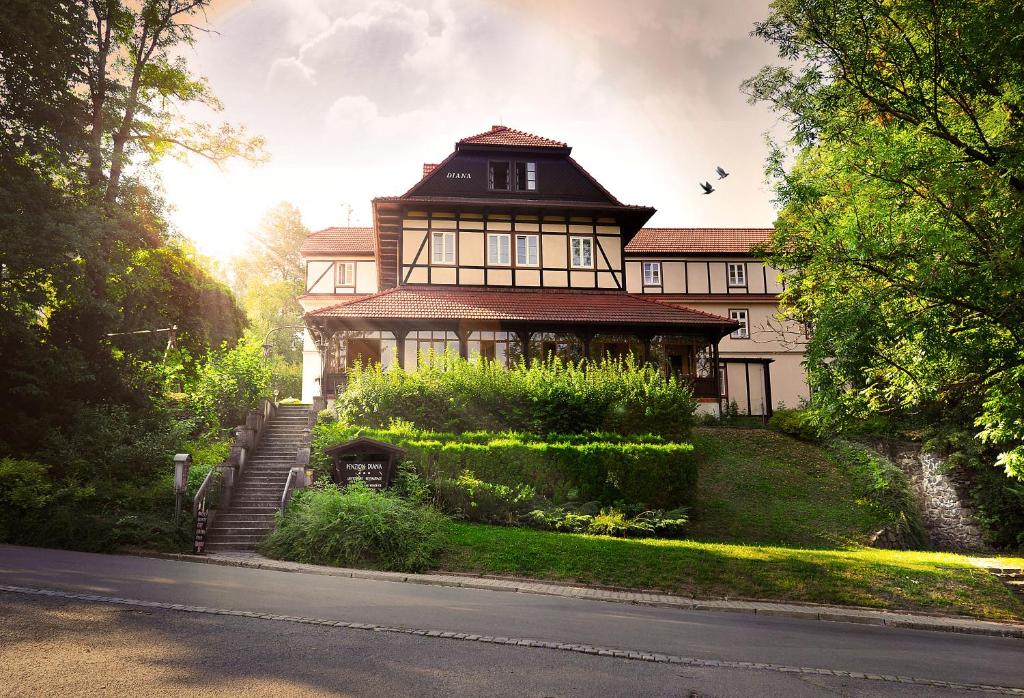 a large house with a staircase in front of it at Penzion Diana in Teplice nad Bečvou