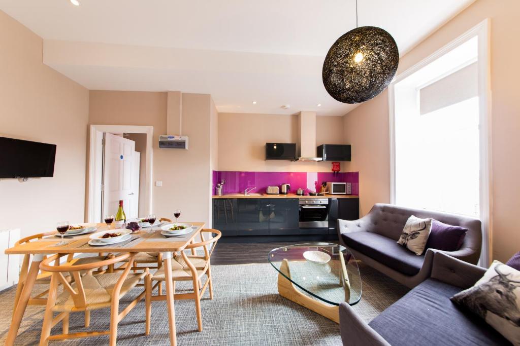 ein Wohnzimmer mit einem Tisch und einem Sofa in der Unterkunft The Spires Serviced Apartments Edinburgh in Edinburgh