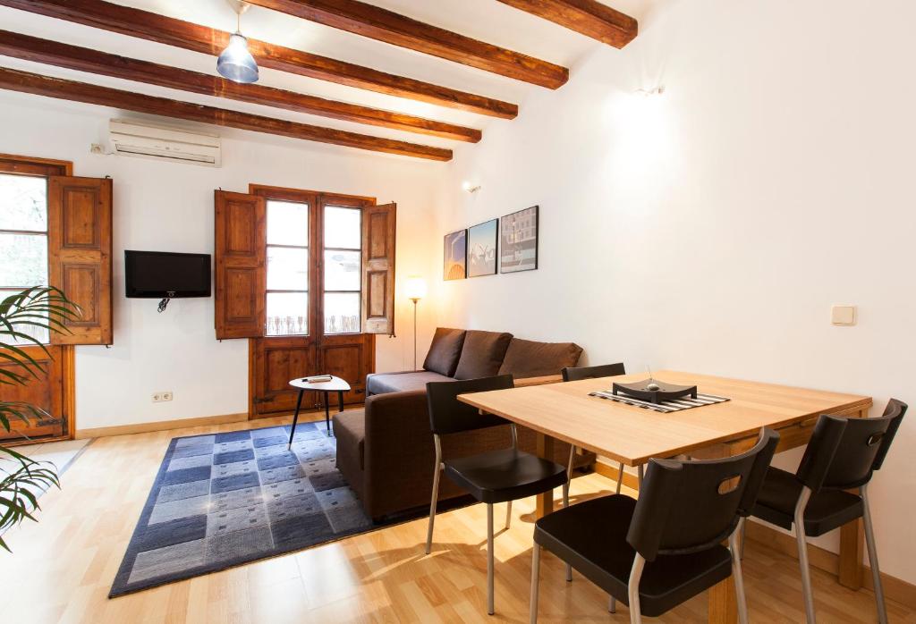 sala de estar con mesa de madera y sillas en AB Centric Barcelona, en Barcelona