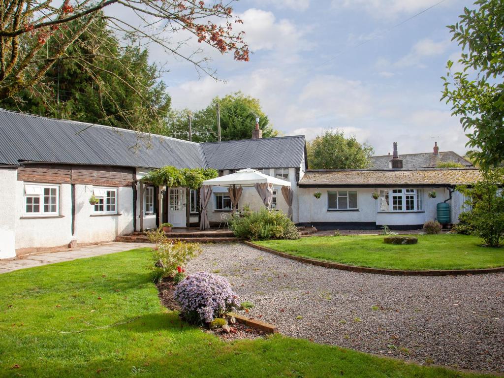 a large white house with a gravel driveway at Little Millhayes in Thorverton