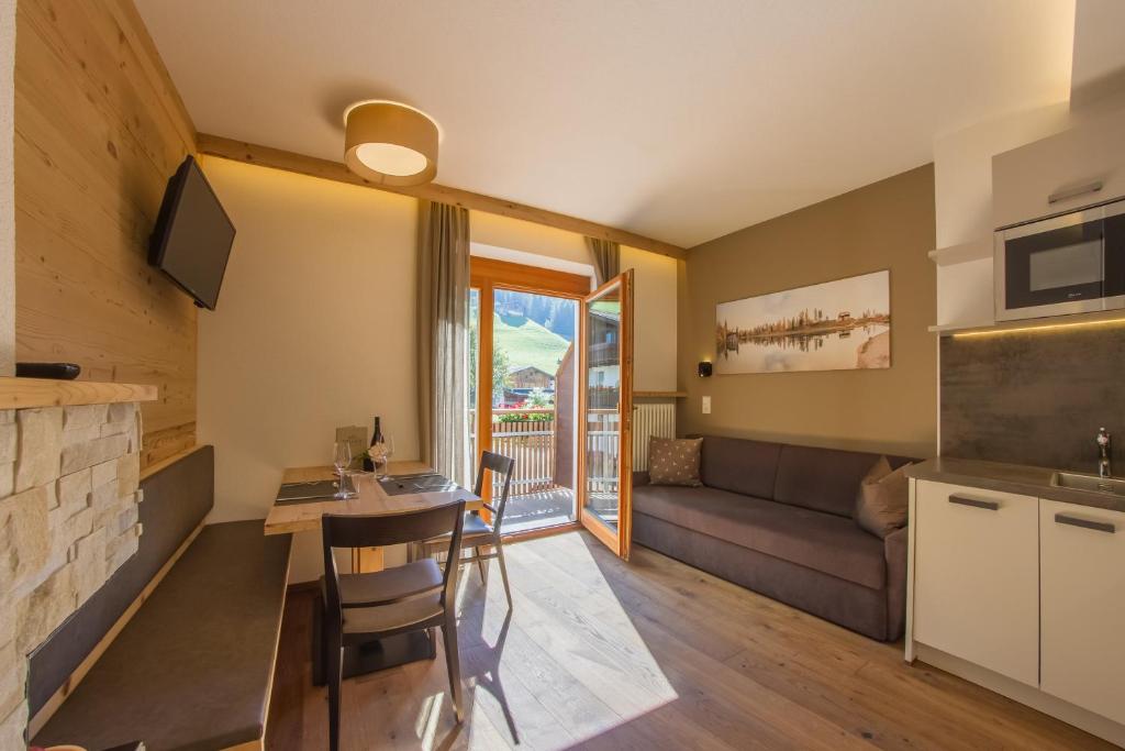 a living room with a couch and a table at Appartement Hotel Erlhof Deluxe in Lutago
