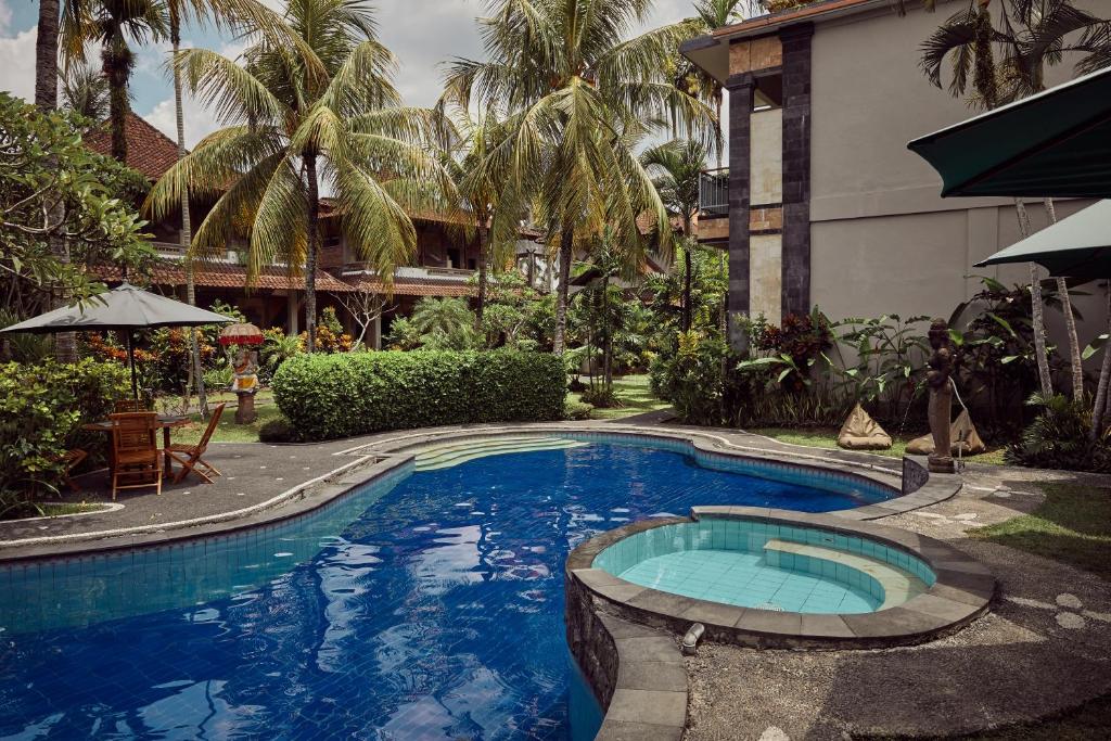 a swimming pool in front of a building at Outpost Ubud Nyuh Kuning in Ubud