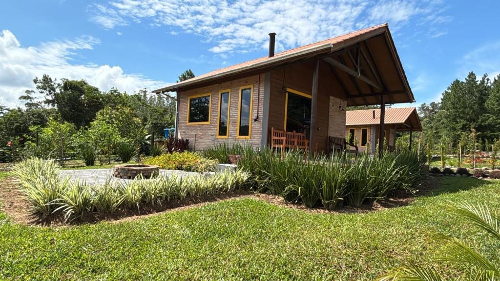 a small cabin in a yard with a grass field at Cabanas Vista da Pedra in Grão Pará