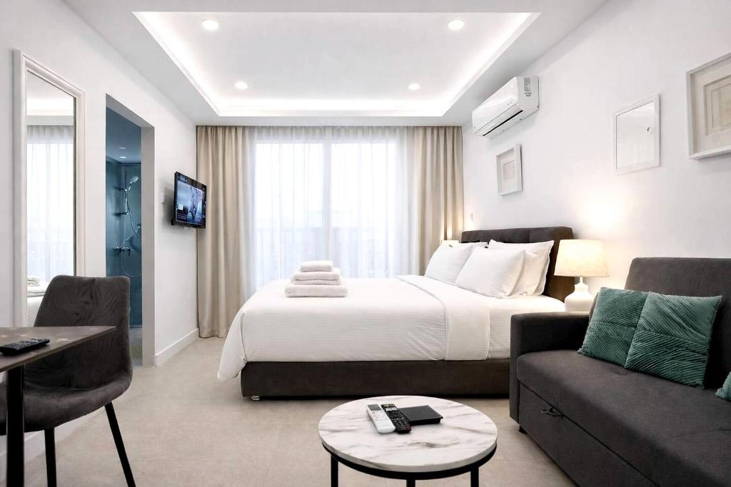 a hotel room with a bed and a living room at White Arches Studio Suite by TrulyCyprus in Limassol