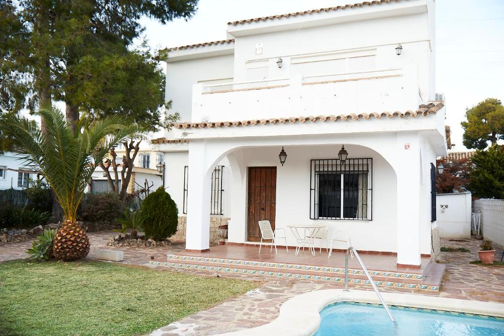a white house with a pool in front of it at Espectacular chalet para descansar in Torrent