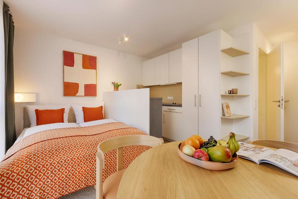 a bedroom with a bed and a bowl of fruit on a table at homie stay am ring - kostenlose Tiefgarage in Würzburg