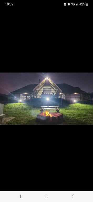 a building with a fire in front of it at night at Rocky Valley Lakehouse in Pietermaritzburg