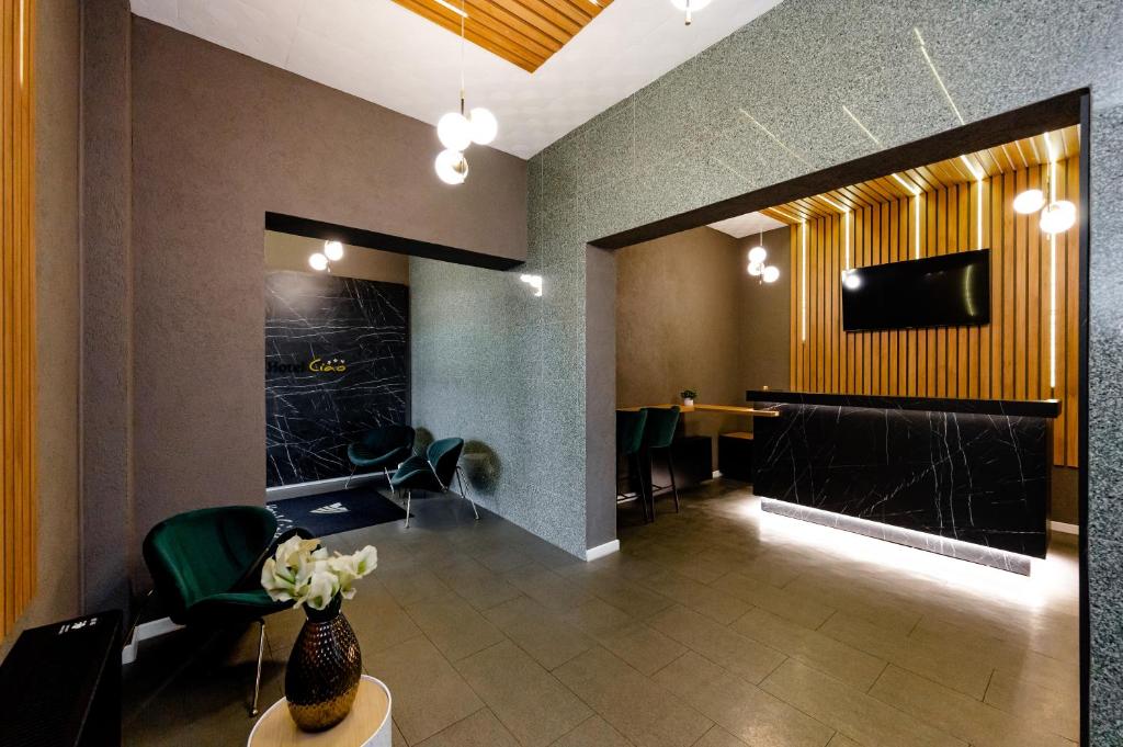 a lobby with a waiting room with a table and chairs at Hotel Ciao in Târgu-Mureş