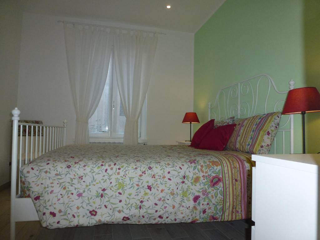 ein Schlafzimmer mit einem großen Bett und einem Fenster in der Unterkunft Il Nido in Gravedona