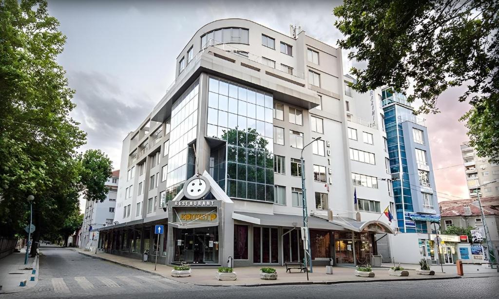 ein großes weißes Gebäude mit einer Uhr darauf in der Unterkunft Alliance Hotel in Plowdiw