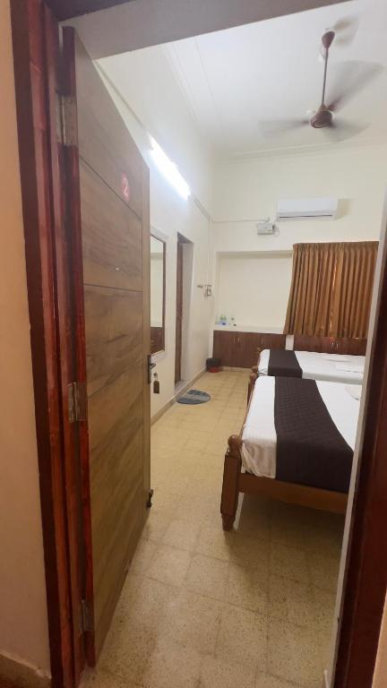 a bedroom with a bed with a black and white blanket at Hotel Madurai Comforts in Madurai