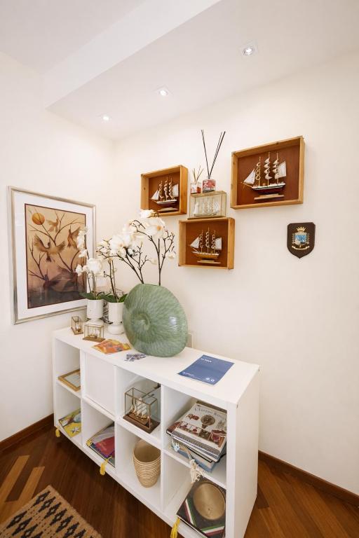 a white shelf with a vase on it in a room at Le VELE in Lido di Ostia