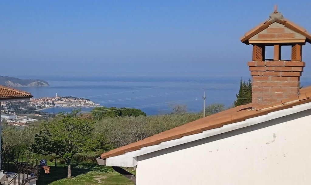 a brick chimney on top of a building with the ocean in the background at Vila Azzuro in Žusterna