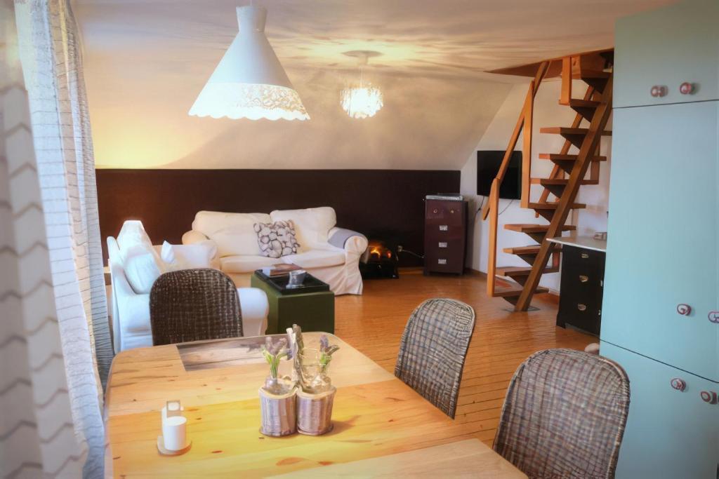a living room with a table and chairs and a couch at Landhaus am Deich in Dornum