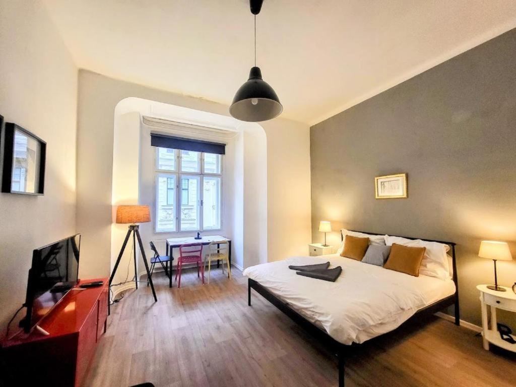 a bedroom with a bed and a desk and a television at Urban Jungle in Brno
