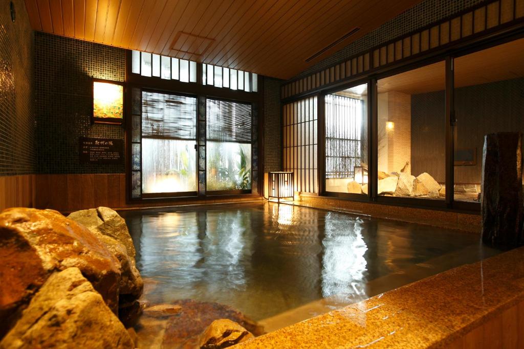 a swimming pool with water in a room with windows at Dormy Inn Premium Wakayama Natural Hot Spring in Wakayama