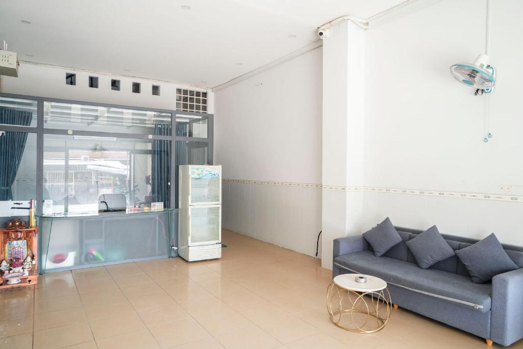 a living room with a blue couch and a table at Nhà Nghỉ Long Nhi in Nhơn Trạch