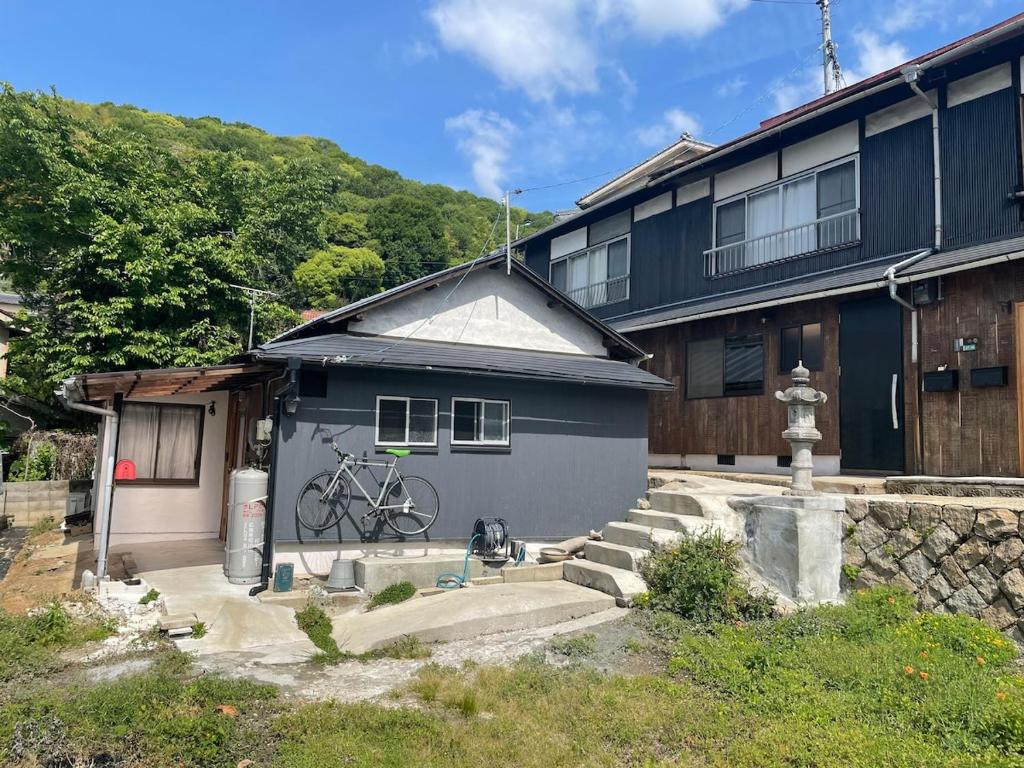 a blue house with a bike parked in front of it at HANARE onomichi in Onomichi