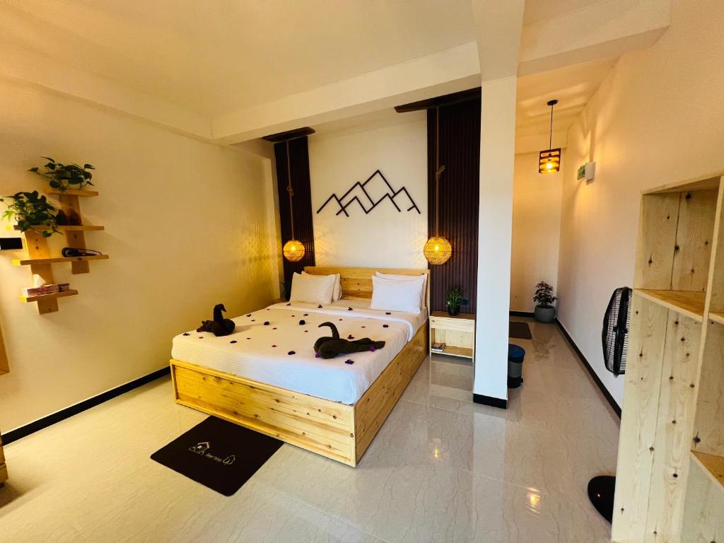 a bedroom with two cats sitting on a bed at Ella Forest Eco View in Ella