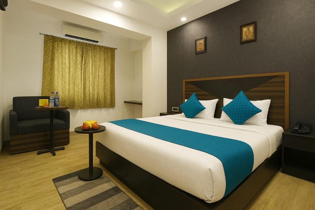 a hotel room with a large bed and a chair at Hotel Grand Delta Near International Airport in New Delhi