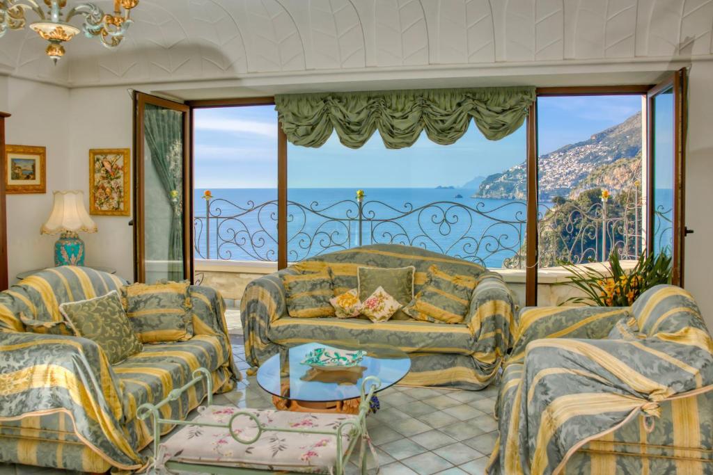 a living room filled with furniture and a large window at Albergo La Conca Azzurra in Conca dei Marini