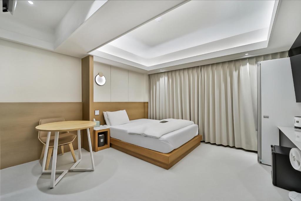 a hotel room with a bed and a table at 9AVENUE hotel in Daegu