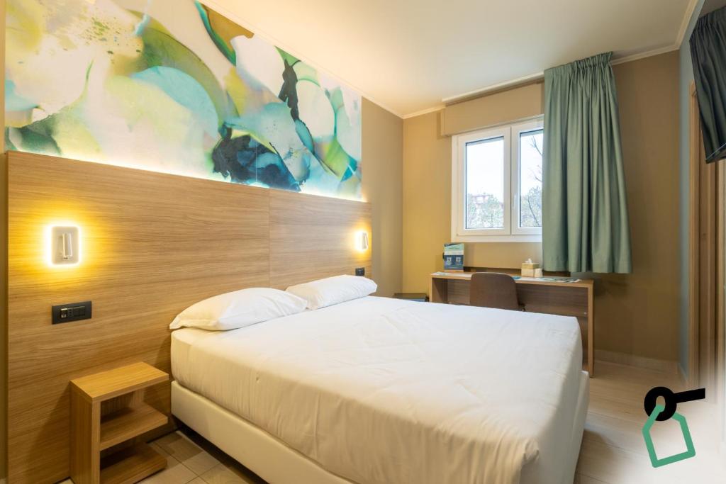 a hotel room with a bed and a desk at Hotiday Conegliano in Conegliano