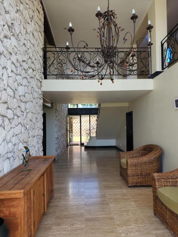a living room with a stone wall and a chandelier at Iconic Villa in Arniston in Arniston